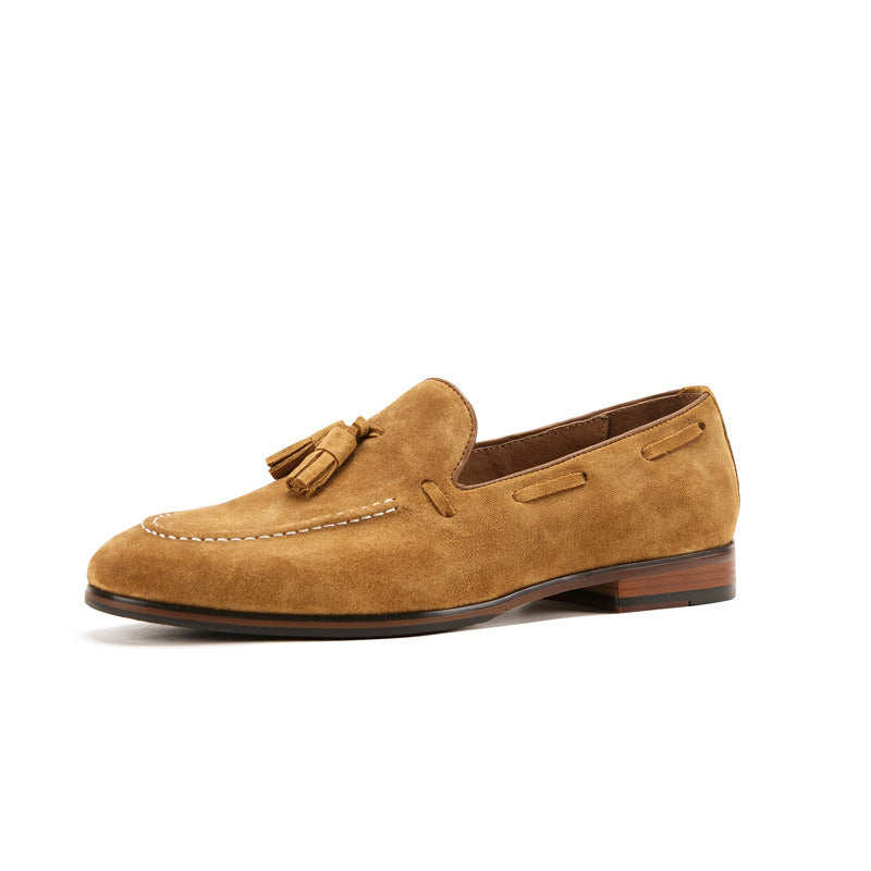 Tan suede loafer with a tassel on a white background