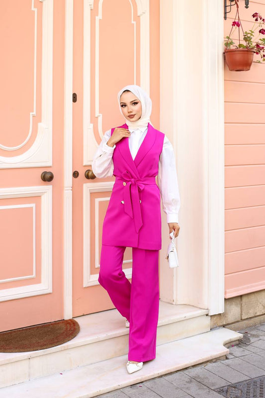 Woman in a pink outfit standing in front of a pink door.