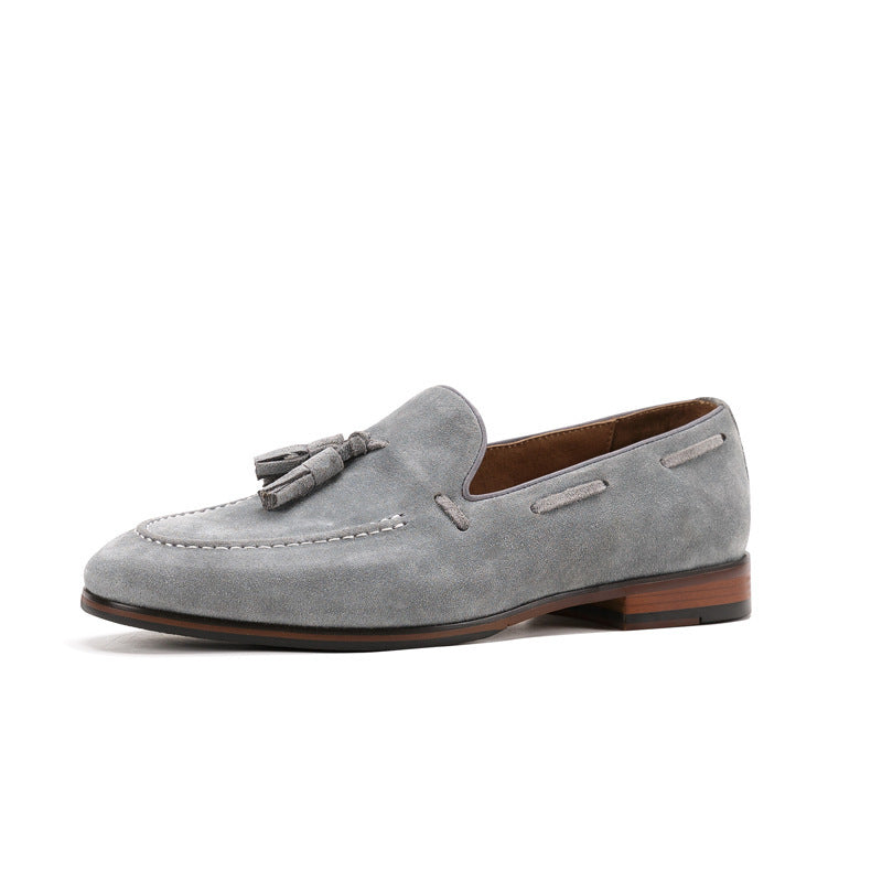 Gray suede loafer with a brown sole on a white background